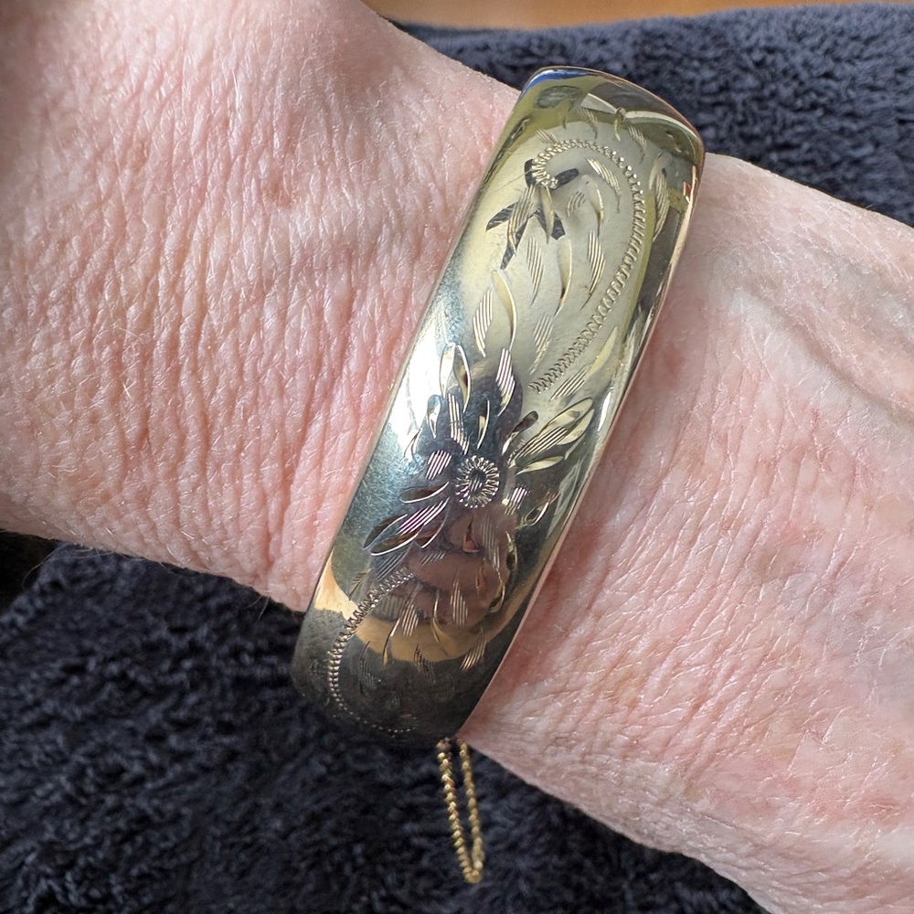 Vintage Engraved Gold-Toned Hinged Bangle Bracelet with safety chain.